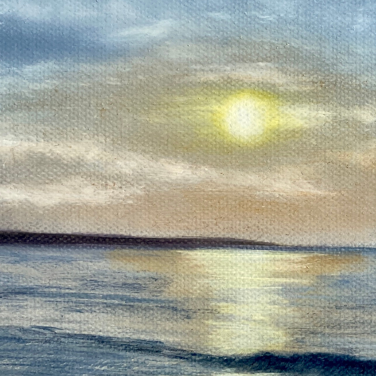 Detail of sunrise over water with a warm glow on the horizon