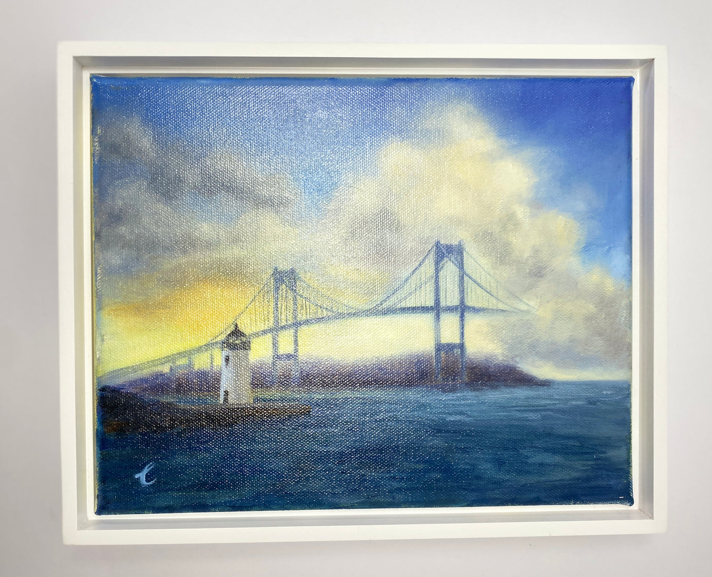 Framed artwork of a Goat Island ighthouse, Newport RI and bridge over water with clouds.