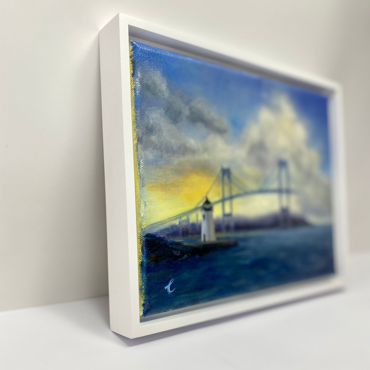 Framed artwork of a Goat Island ighthouse, Newport RI and bridge with a white border.