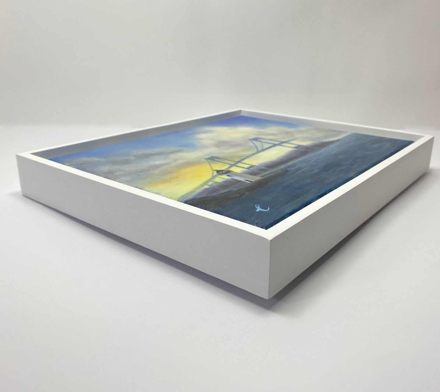 Framed artwork of a lighthouse on water with a white frame