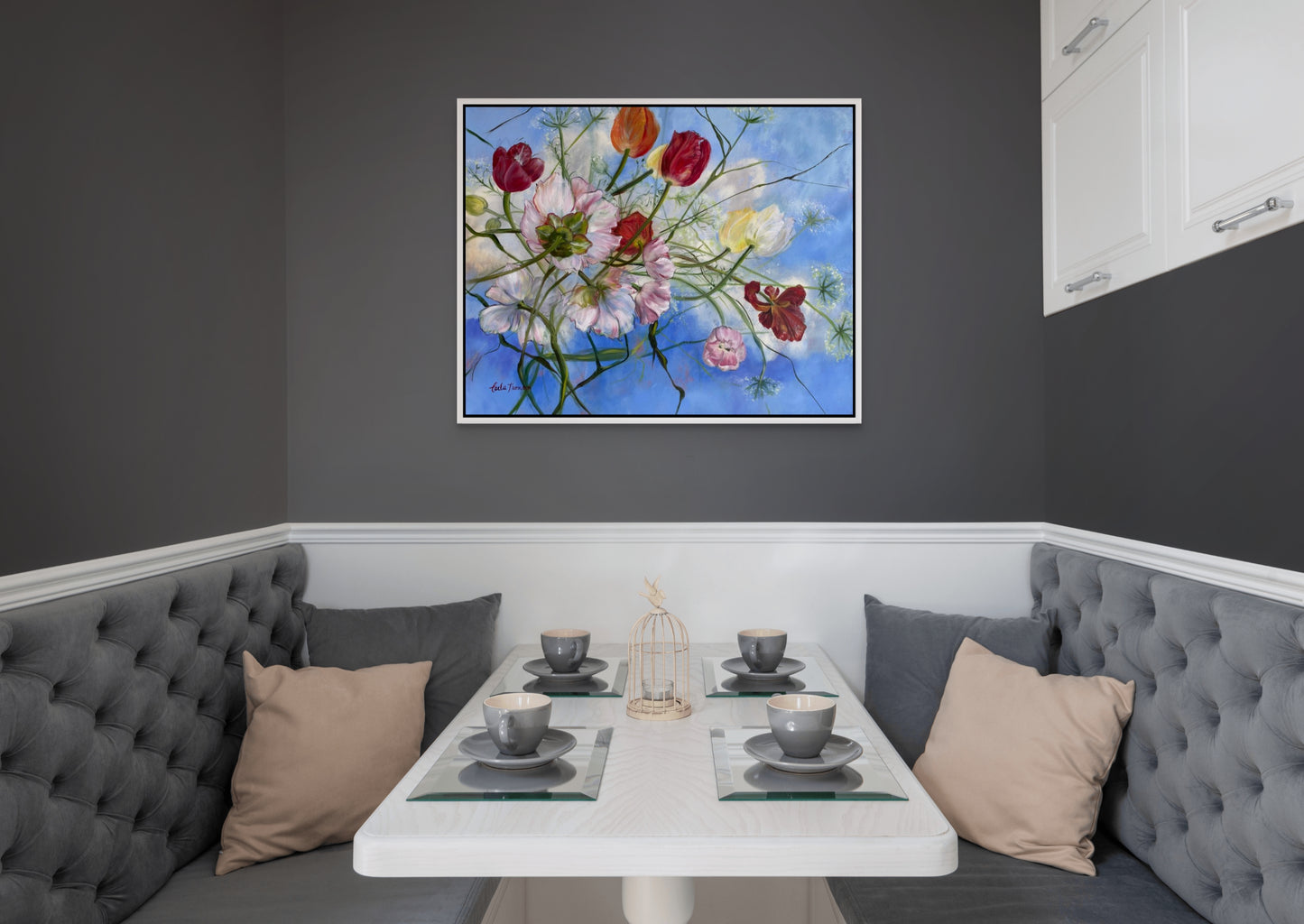 Wishful Thinking a colorful original floral oil painting on a gray wall over a Dining area with gray booth seating, and a small table set for four.