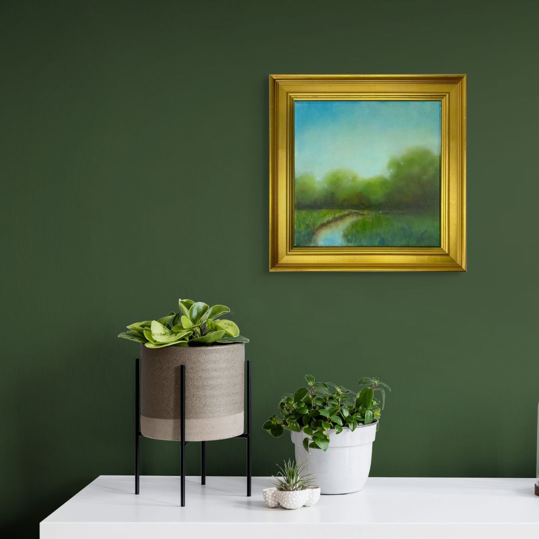 Gold Framed original tonal oil landscape painting on a green wall with potted plants below