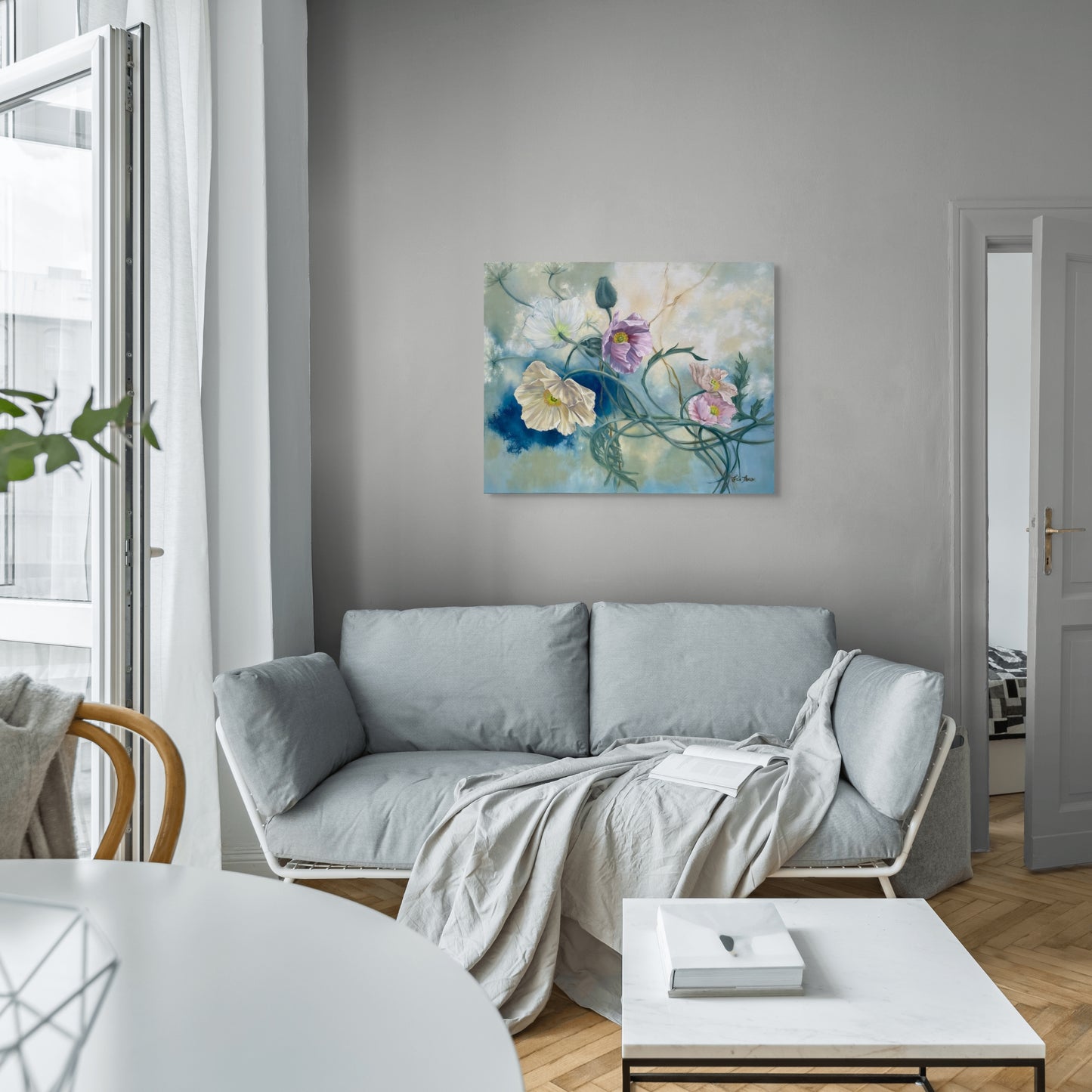 Modern living room with a gray sofa, white coffee table, and original floral oil painting Tangled Reverie on the wall.