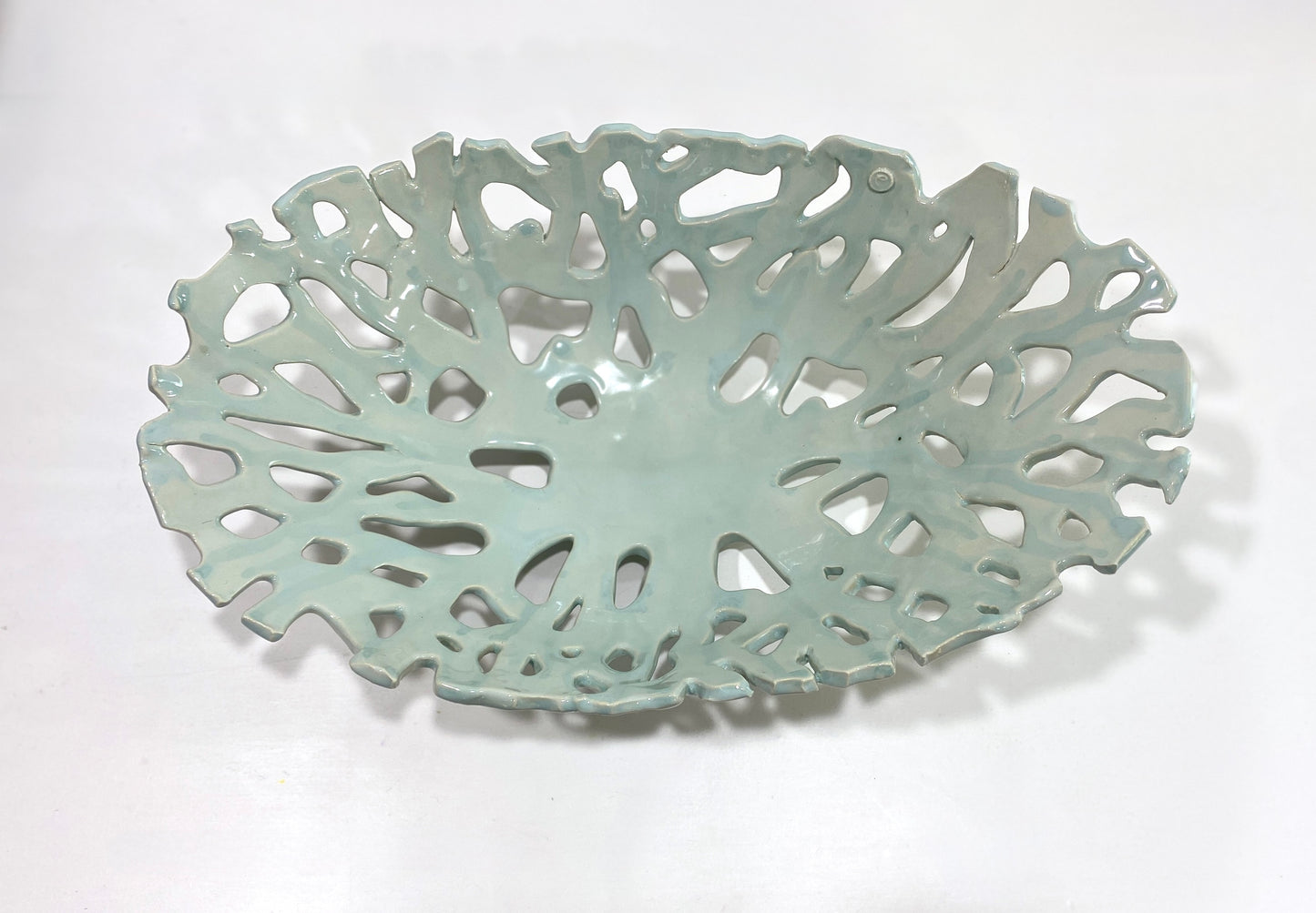 Openwork: Coastal — Seaglass, three-quarter overhead view showing full openwork pattern and luminous celadon surface
