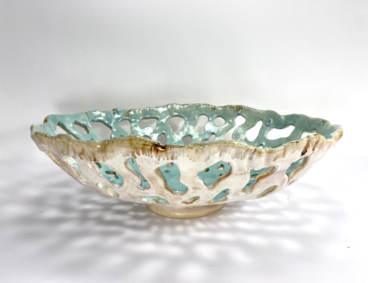 Openwork: Coastal — Tidepool, three-quarter view showing cream and earth exterior glaze with celadon interior