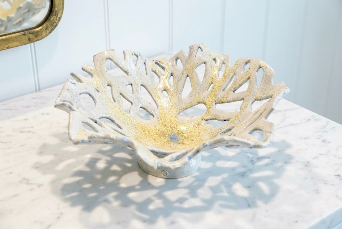 Openwork: Coastal — Reef ceramic bowl on marble surface, showing white-to-gold crystal glaze with blue flecks and coral-like openwork form