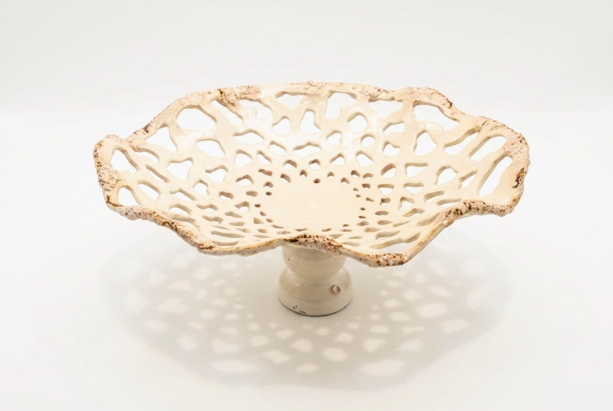 Openwork: Coastal — Sanddollar on white background, overhead view showing dense radiating openwork pattern and cream glaze