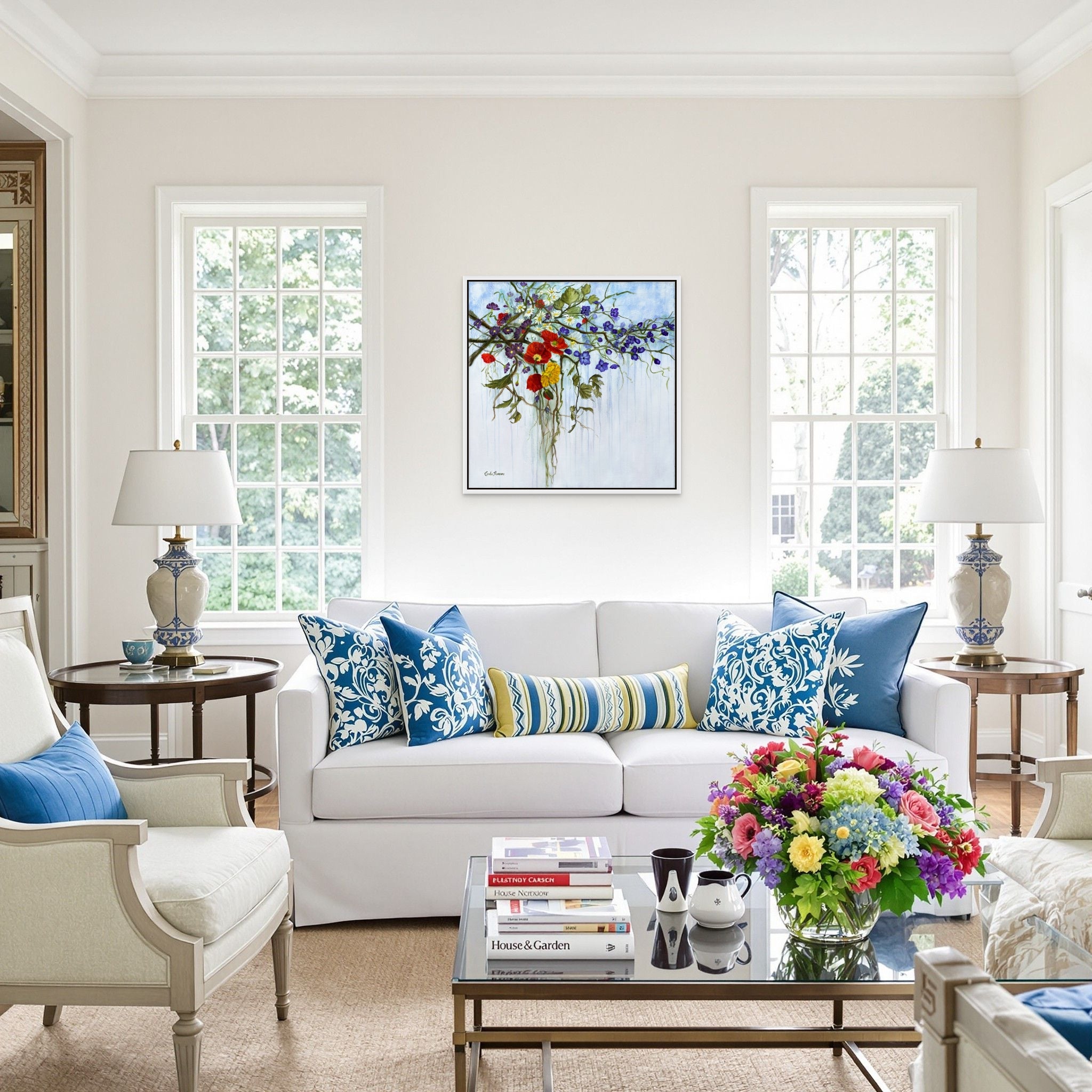 Living room with a white sofa, colorful pillows, and a coffee table with books and a vase.