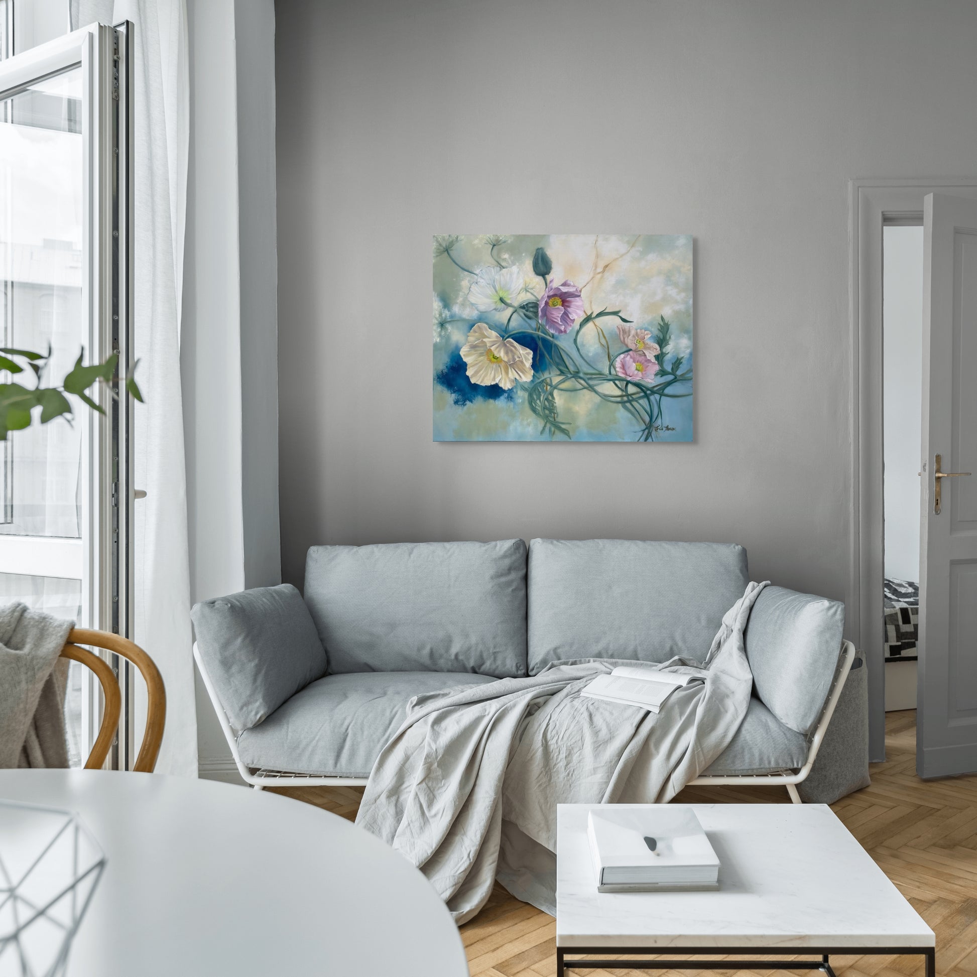 Modern living room with a gray sofa, white coffee table, and original floral oil painting Tangled Reverie on the wall.